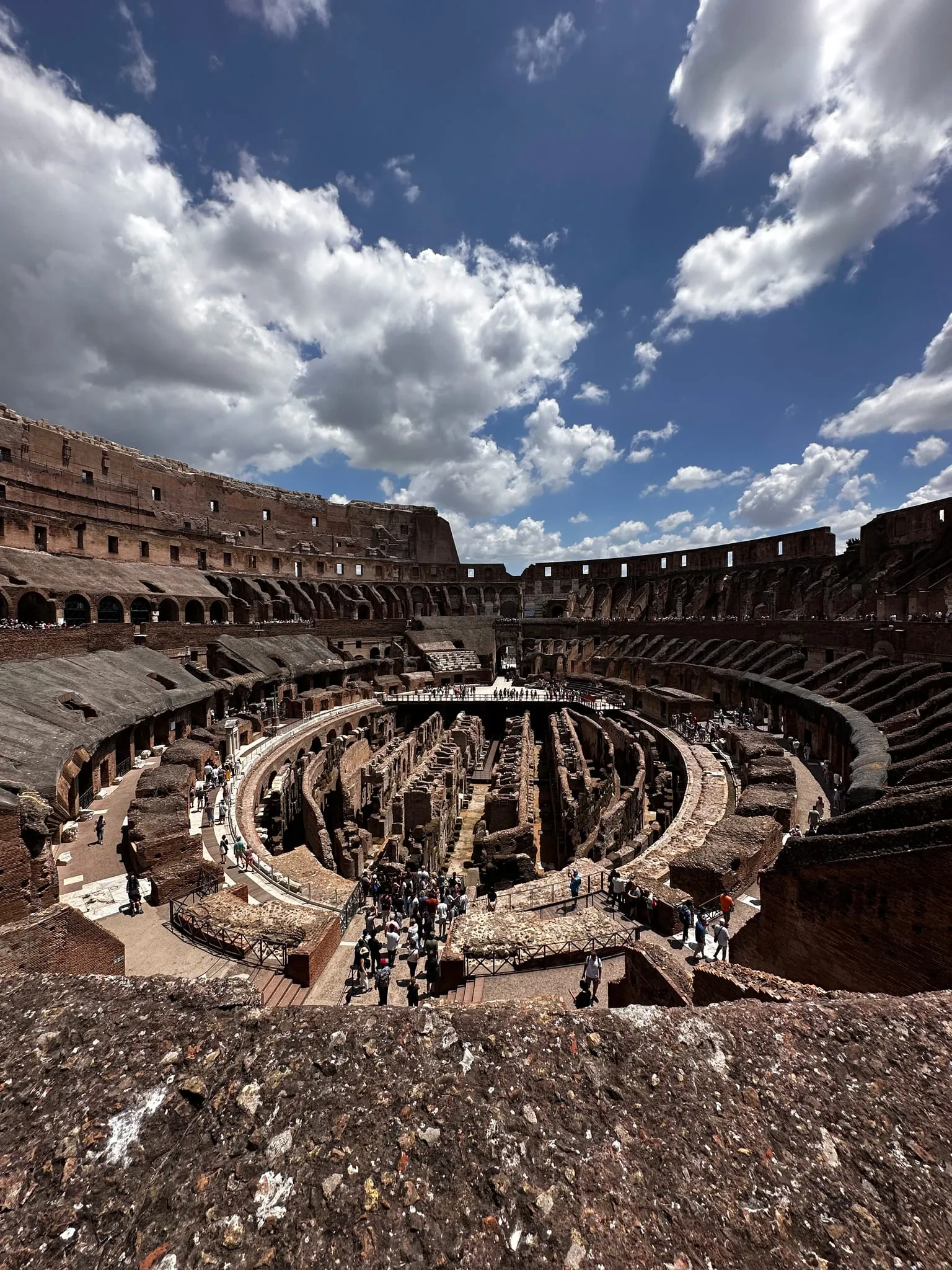 Inside the Colosseum in Rome under a cloudy sky