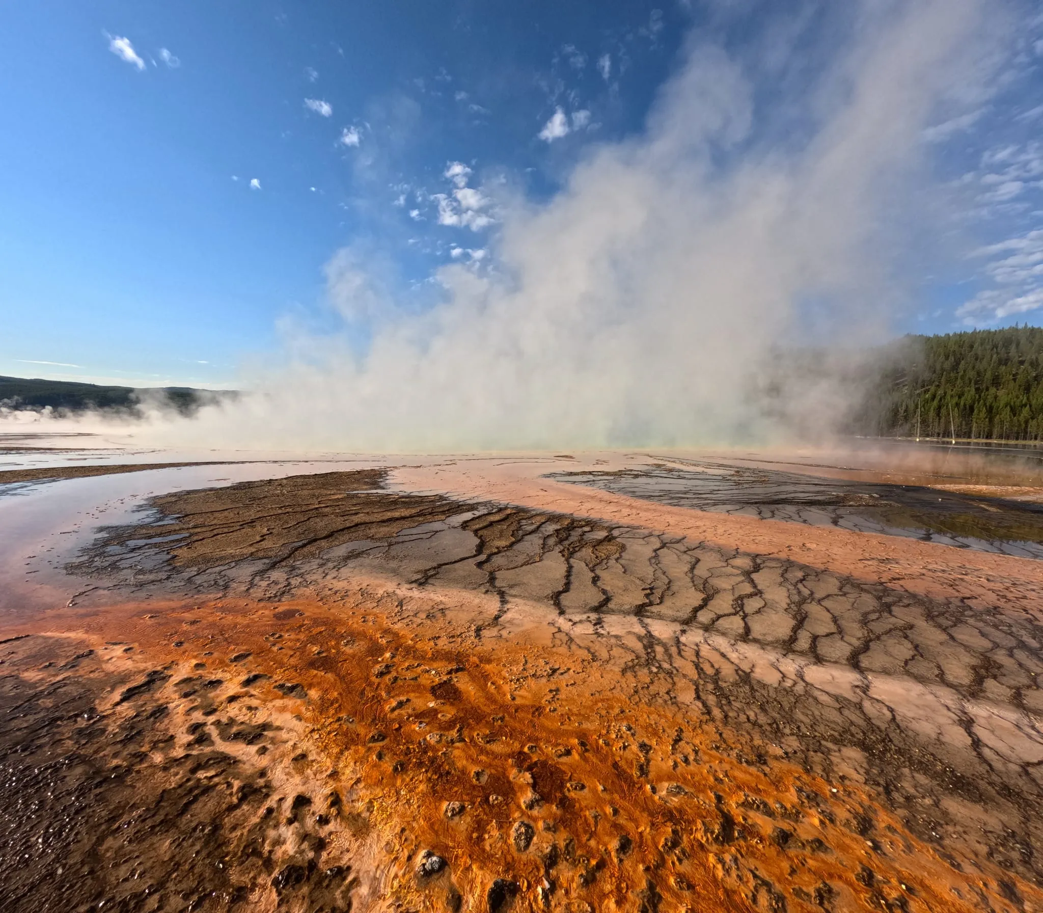 Steam over the orange runoff of Grand Prismatic Spring