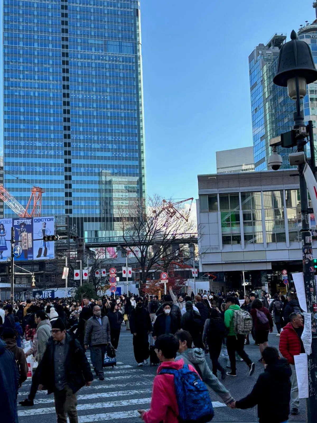 A crowd at a busy Tokyo intersection under tall buildings