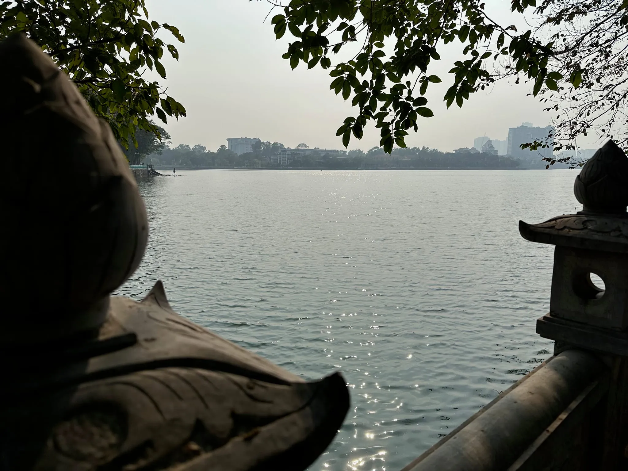 A lake in Hanoi seen past a carved stone dragon