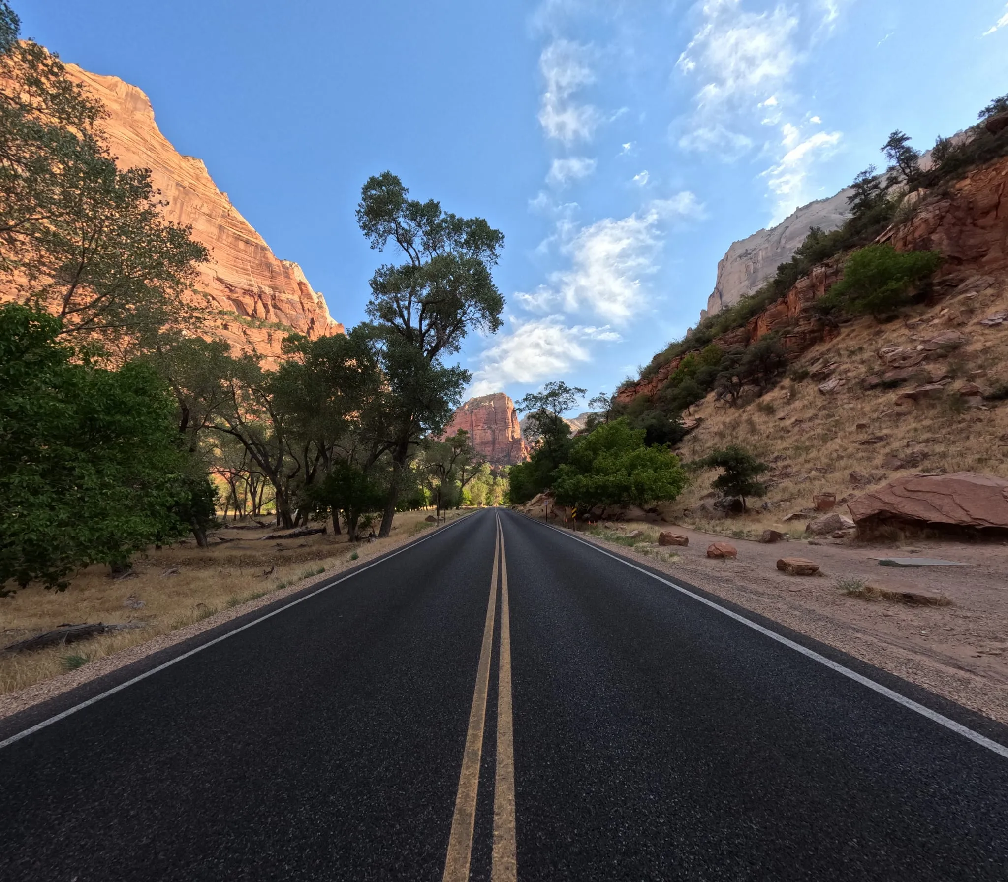 An empty road running between cliffs in Zion