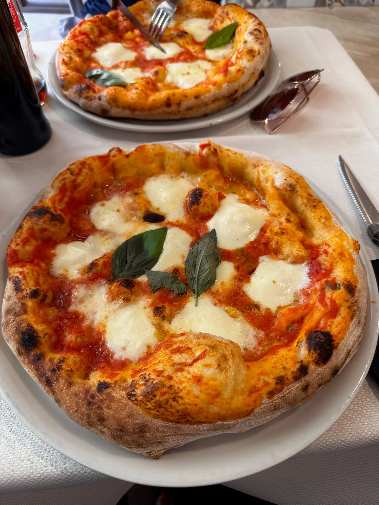 A margherita pizza on a white plate