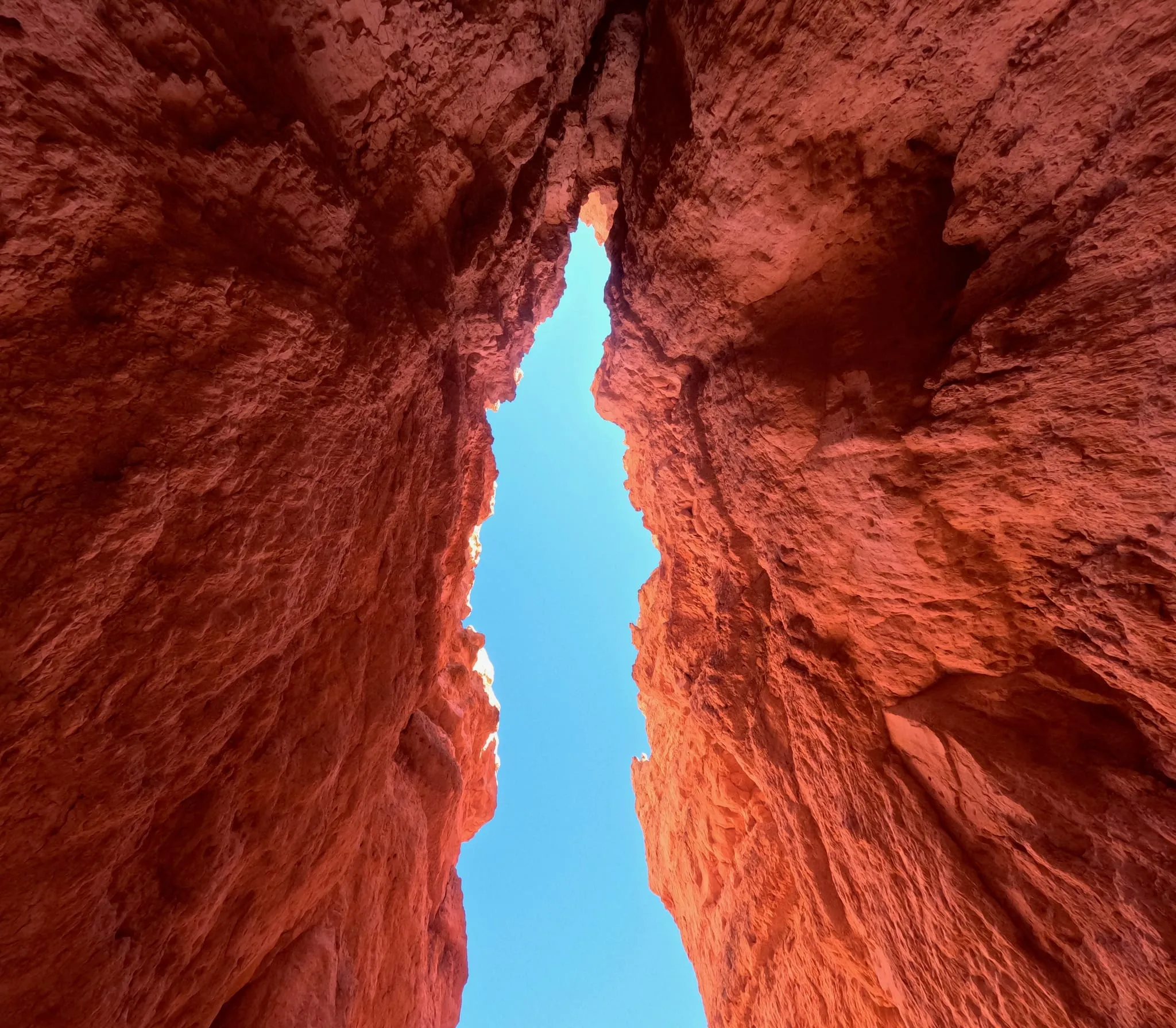 Looking up a narrow slot of red rock to blue sky