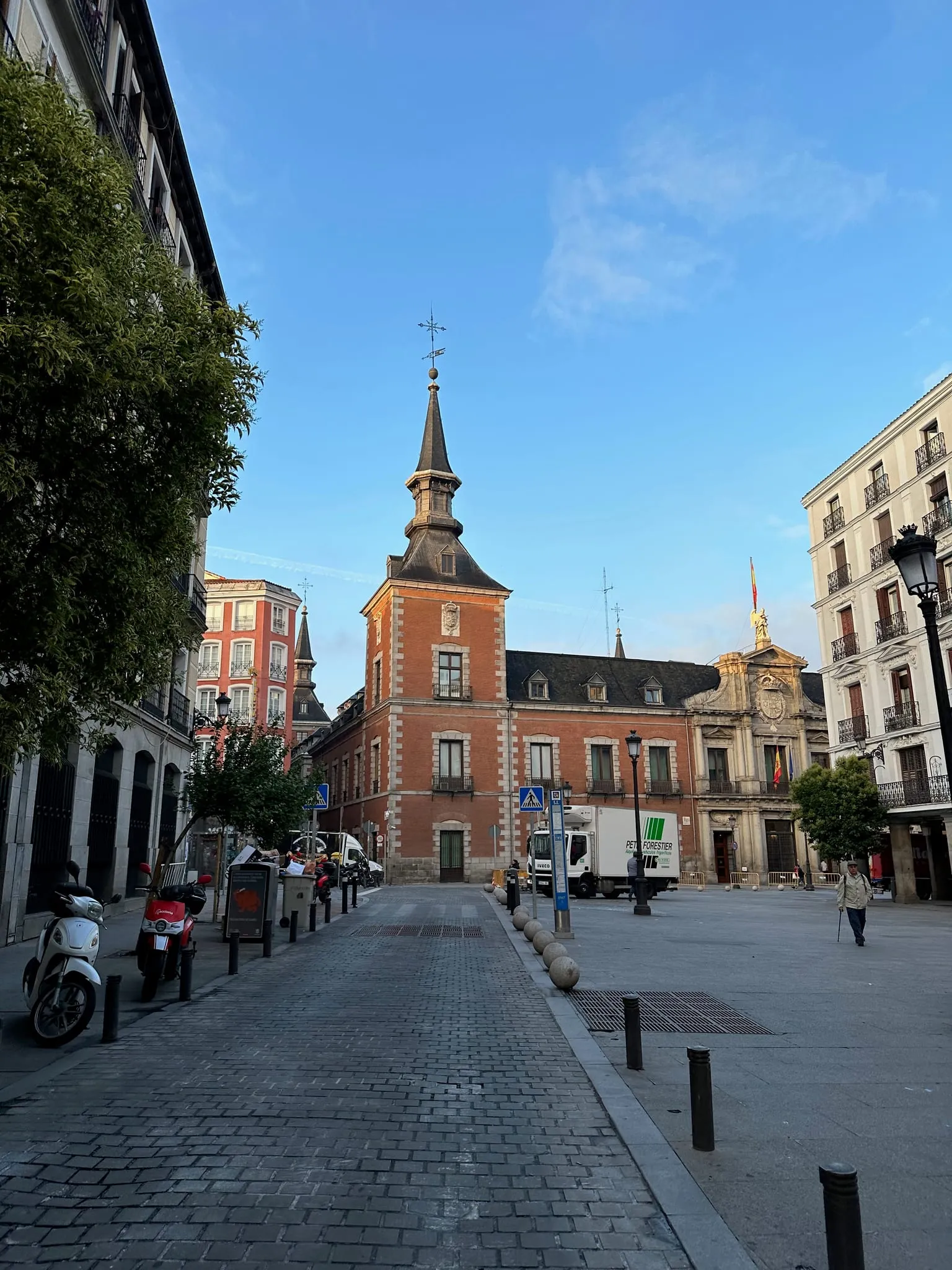 A red brick palace with a spire on a quiet street in Madrid